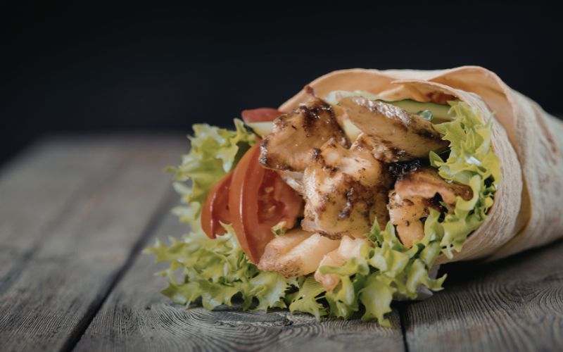 Shawarma platter with rice, salad, hummus, and sauces